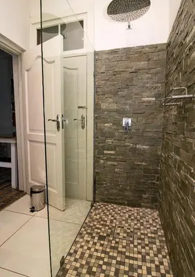 a bathroom with a shower with a glass door at The Doors Inn in Mokopane