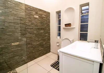 a bathroom with a sink and a glass shower at The Doors Inn in Mokopane