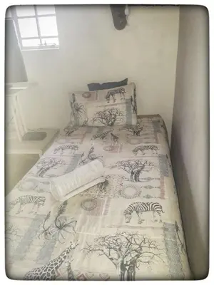 a bed with a bedspread with zebras on it at Buster's River Lodge in Marloth Park