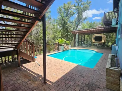 a swimming pool on a brick patio with a pergola at Bokmakierie Place in Modimolle