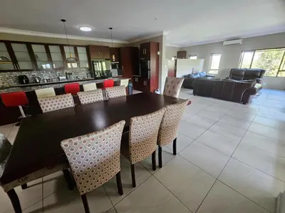 a dining room and kitchen with a table and chairs at Bokmakierie Place in Modimolle