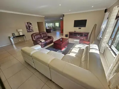 a living room with a couch and a tv at Bokmakierie Place in Modimolle