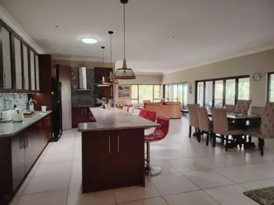a kitchen and living room with a table and chairs at Bokmakierie Place in Modimolle