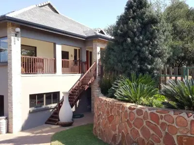 a house with a retaining wall and a staircase at Bokmakierie Place in Modimolle