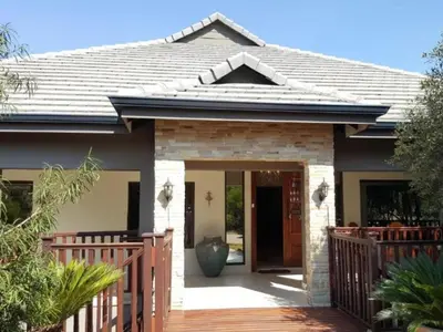 a house with a wooden fence and a porch at Bokmakierie Place in Modimolle