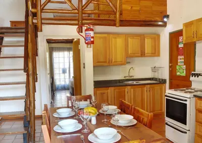 a kitchen with a wooden table with chairs and a dining room at Burchell's Bush Lodge by Dream Resorts in Sabi Sand Game Reserve