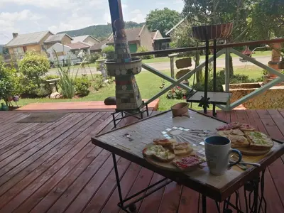 a table with two slices of pizza on a deck at House of Art in Haenertsburg
