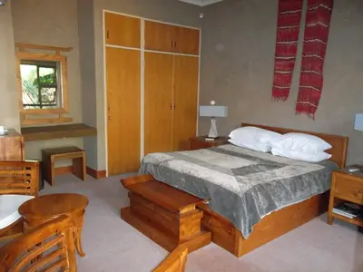 a bedroom with a bed and a table and a chair at Ku De Ta B&B in White River