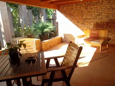 a patio with a wooden table and chairs at Ku De Ta B&B in White River