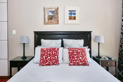 a bedroom with a bed with red and white pillows at 1202 on Cowgill in Pretoria