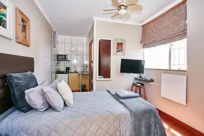 a bedroom with a bed and a ceiling fan at 1202 on Cowgill in Pretoria