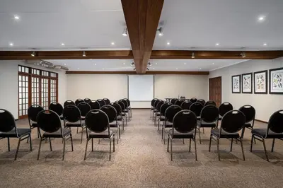 a room filled with chairs and a white screen at Premier Hotel Roodevalley in Pretoria
