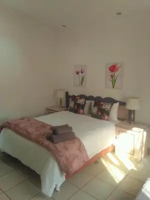 a bedroom with a large bed with flowers on it at BellaMaria in Pretoria