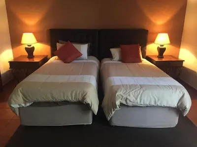 two beds in a hotel room with two lamps at Baobab Lane Lodge in Marnitz