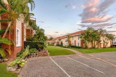 a row of houses with palm trees and a driveway at Protea Hotel by Marriott Nelspruit in Nelspruit