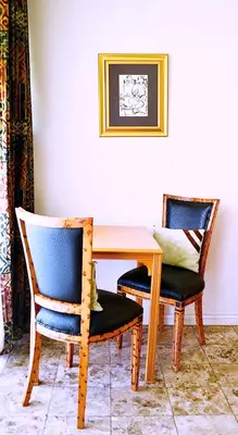 a wooden table with two chairs and a table with at Brooklyn Lodge in Pretoria