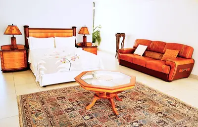 a bedroom with a bed and a couch and a coffee table at Brooklyn Lodge in Pretoria
