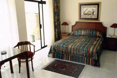 a bedroom with a bed and a table and a table sidx sidx sidx at Brooklyn Lodge in Pretoria