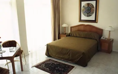 a bedroom with a bed and a table and a table sidx sidx sidx at Brooklyn Lodge in Pretoria