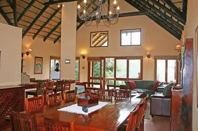 a dining room with a large wooden table and chairs at Verlorenkloof in Dullstroom