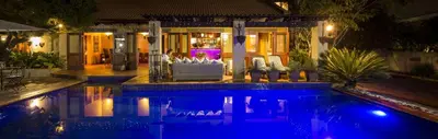 a swimming pool in front of a house at night at Opikopi Guest House in Pretoria