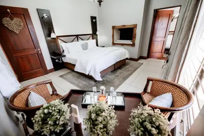 a bedroom with a bed and a table and chairs at Opikopi Guest House in Pretoria