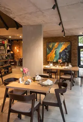 a dining room with tables and chairs and a painting at Opikopi Guest House in Pretoria