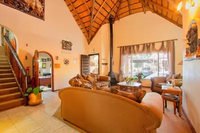 a living room with couches and a table at All over Africa Guest house in Kempton Park
