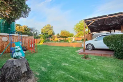 a garden with a car parked in a yard at All over Africa Guest house in Kempton Park