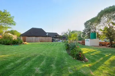 a large yard with a barn and some flowers at All over Africa Guest house in Kempton Park