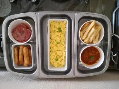 a tray of food with a meal with french fries at All over Africa Guest house in Kempton Park