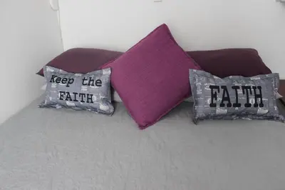 three pillows with the words keep the faith on a bed at PhysEQFiT Guesthouse & Spa in Centurion