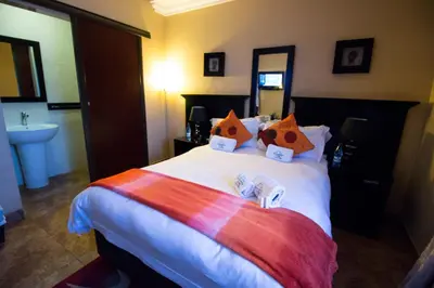 a hotel room with a large bed with a sink at The Shamrock Hotel in Polokwane