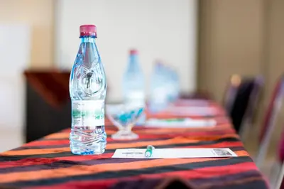 a bottle of water sitting on top of a table at The Shamrock Hotel in Polokwane