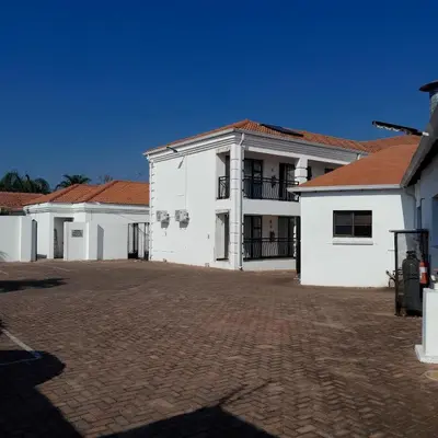 a row of white buildings with red roofs at The Shamrock Hotel in Polokwane