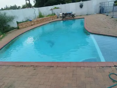 a swimming pool with blue water in a backyard at Elsjes Guesthouse in Kempton Park