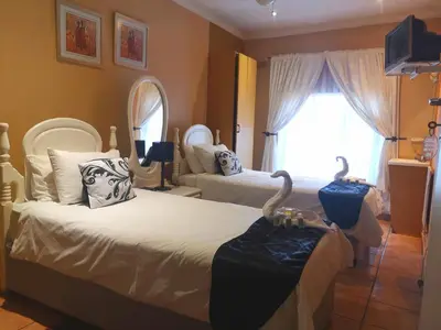 a bedroom with two beds and a large window at Elsjes Guesthouse in Kempton Park