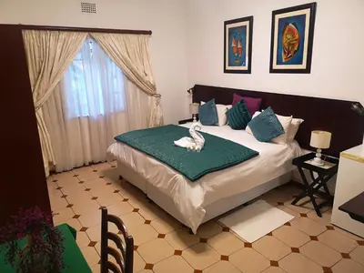 a bedroom with a bed with a bird on a blanket at Elsjes Guesthouse in Kempton Park