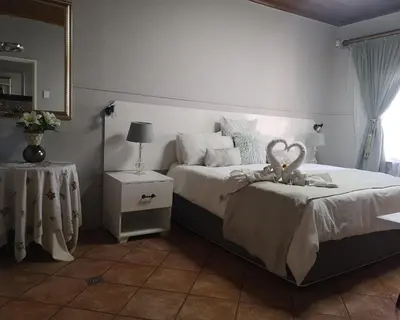 a bedroom with a bed with a teddy bear on it at Elsjes Guesthouse in Kempton Park