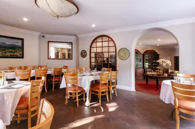 a dining room with white tables and chairs at Murray Street 137 Guesthouse in Pretoria