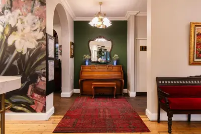 a hallway with a piano and a mirror at Murray Street 137 Guesthouse in Pretoria