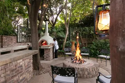 a man standing in front of a fire pit at Murray Street 137 Guesthouse in Pretoria