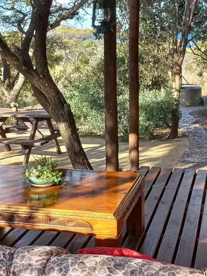 a wooden table sitting on a wooden deck at Five Pebbles on Piece of Africa in Cullinan