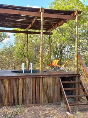 a wooden pergola with a sink and chairs under it at Five Pebbles on Piece of Africa in Cullinan