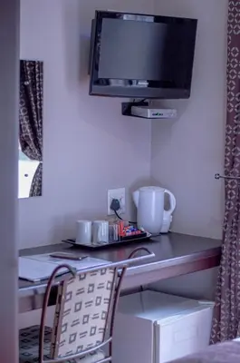 a room with a desk with a tv and a chair at 314 on Clark Guest House in Pretoria