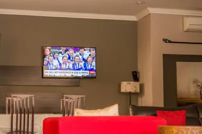 a living room with a flat screen tv on the wall at 314 on Clark Guest House in Pretoria