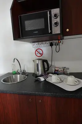 a kitchen counter with a sink and a microwave at Brooklyn Guesthouses in Pretoria