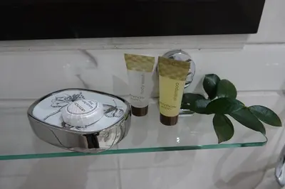 a glass shelf with two candles and a plant on it at Brooklyn Guesthouses in Pretoria