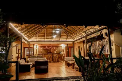 a living room with couches and chairs and a table at Sunbird Lodge in Phalaborwa