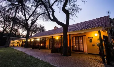 a building with trees in front of it at Sunbird Lodge in Phalaborwa